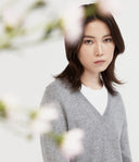 Kobieta w jasnoszarym dzianinowym swetrze w ujęciu studyjnym