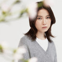 Kobieta w jasnoszarym dzianinowym swetrze w ujęciu studyjnym